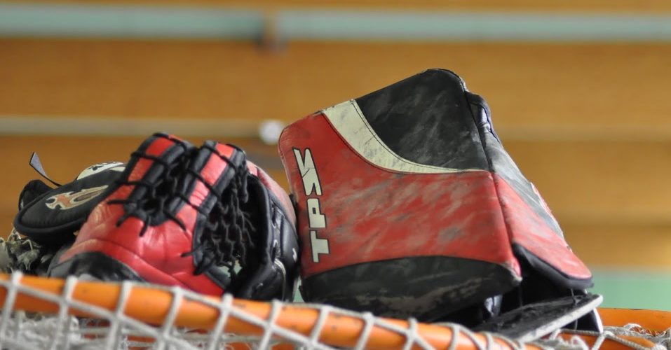 Gants sur cage de roller-hockey à Roulez Rose